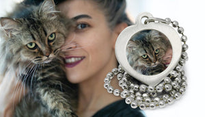Woman holding cat close to face with cat photo necklace